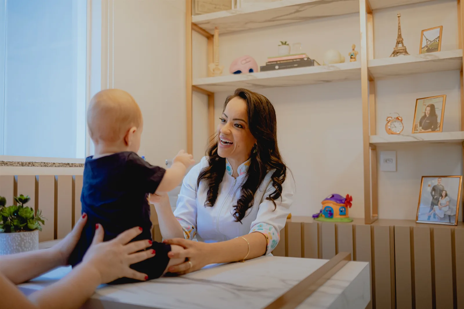 Dra. Ligiane Gama sorrindo durante atendimento de osteopatia pediátrica em seu consultório em Sinop